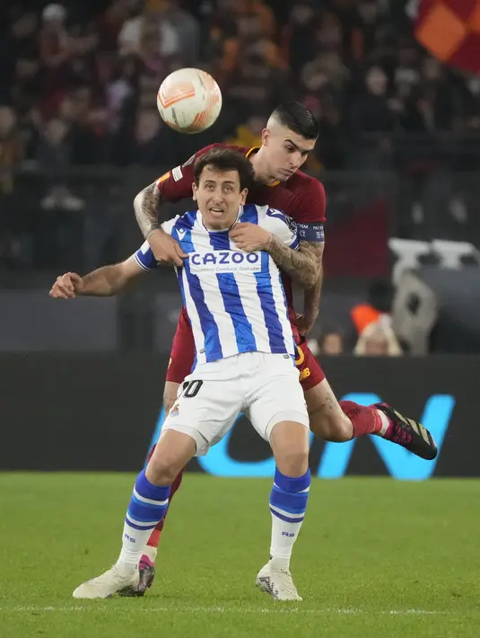 Penyerang Real Sociedad, Mikel Oyarzabal dan bek AS Roma Gianluca Mancini melakukan sundulan saat bersaing pada laga pertama babak 16 besar Liga Europa 2022/2023 di Olimpico, Jumat (10/3/2023) dini hari WIB. Dua gol kemenangan Roma atas Sociedad masing-masing diciptakan oleh Stephan El Shaarawy di babak pertama dan Marash Kumbulla di babak kedua. (AP Photo/Gregorio Borgia)