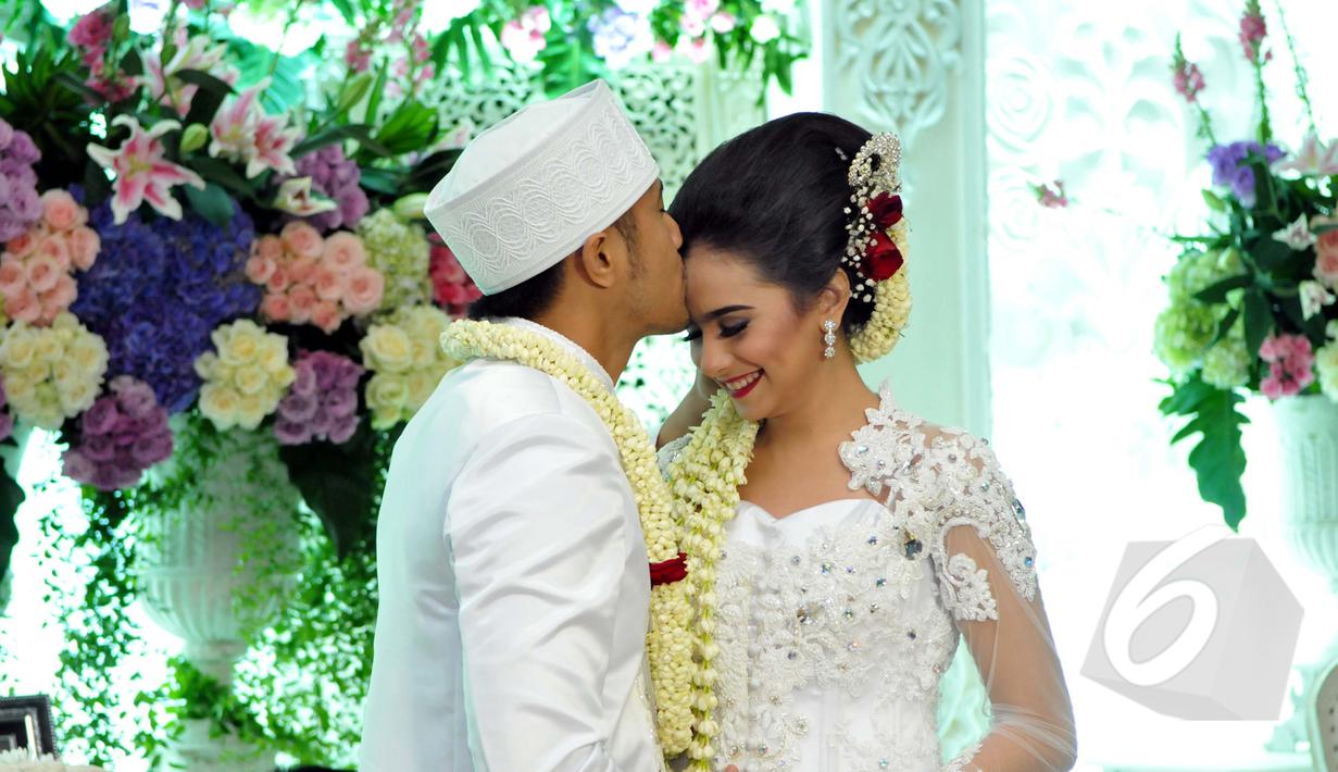 Hengky Kurniawan saat mencium kening Sonya Fatmala usai melangsungkan akad nikah di sebuah hotel kawasan TMII, Jakarta, Kamis (23/4/2015). (Liputan6.com/Panji Diksana)