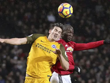 Duel pemain Brighton, Lewis Dunk (kiri) dan pemain Manchester United, Romelu Lukaku pada lanjutan Premier League di Old Trafford, Manchester,(25/11/2017). Manchester United menang tipis 1-0. (Martin Rickett/PA via AP)