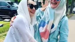 Reza Artamevia ke makam Adjie Massaid mengenakan baju oversized putih lengan panjang dibalut kerudung warna senada. Pelantun “Satu Yang Tak Bisa Lepas” pakai kaca mata hitam. Sementara Puteri Indonesia 2001 mengenakan hijab biru motif abstrak yang dipadukan dengan busana mulim warna senada dan kacamata. Keduanya berpeluk di permakaman Jeruk Purut Jakarta. (Foto: Dok. Instagram @rezaartameviaofficial)