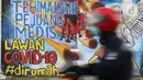 Pengendara motor melintasi mural ajakan melawan COVID-19 di Depok, Jawa Barat, Selasa (14/4/2020). Pemprov Jabar memulai pembatasan sosial skala besar di Bogor, Depok, Bekasi pada Rabu (15/4) dengan menyiapkan anggaran Rp4 triliun sebagai jaring pengaman sosial. (Liputan6.com/Helmi Fithriansyah)