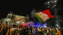 Suporter merayakan kemenangan Italia atas Inggris pada pertandingan final Euro 2020 di Roma, Italia, Senin (12/7/2021). Italia menjuarai Euro 2020 usai mengalahkan Inggris lewat drama adu penalti pada pertandingan final. (AP Photo/Alessandra Tarantino)