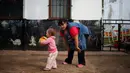 Noelia Garella bermain dengan seorang murid di TK Jeromito, Cordoba, Argentina (24/10). Noelia 31 tahun merupakan penderita down syndrome pertama yang menjadi guru TK. (AFP Photo/Diego Lima)