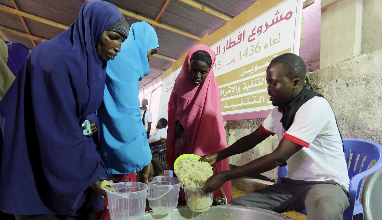 Warga Somalia saat menerima iftar (makanan berbuka puasa) dari sebuah organisasi amal Qatar selama bulan suci Ramadan, di ibukota Mogadishu, Senin (22/6/2015). (REUTERS/Feisal Omar)