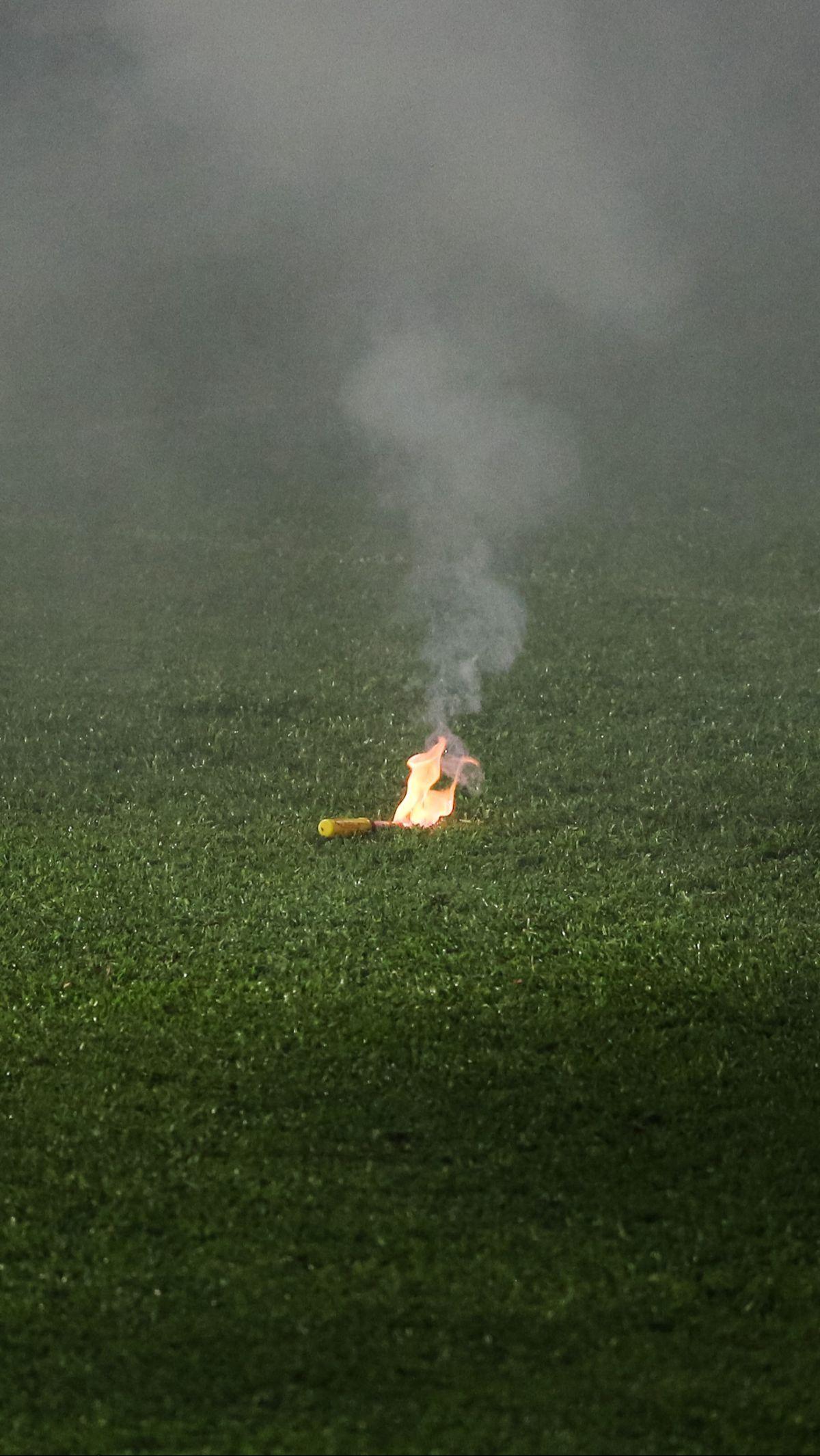 Penampakan sebuah flare yang terbakar di tengah lapangan hijau.&nbsp;Bola.com/Bagaskara Lazuardi