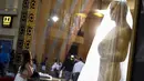 Seorang wanita berpose di dekat patung Oscar 2016 di luar Teater Dolby, Hollywood, California, Sabtu (27/2). Acara penghargaan Academy Awards ke-88 ini akan berlangsung pada Minggu (28/2) waktu setempat. (REUTERS/Adrees Latif)