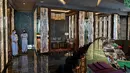 Karyawan berdiri di bar J Hotel, hotel mewah tertinggi di dunia, di Menara Shanghai, Shanghai pada 23 Juni 2021. Hotel ini merupakan bagian dari Jin Jiang International Hotels, sebuah grup besar milik pemerintah China. (Hector RETAMAL / AFP)