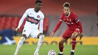 Pemain Midtjylland, Sory Kaba membawa bola dari kawalan pemain Liverpool, Rhys Williams pada pertandingan grup D Liga Champions di stadion Anfield, di Liverpool, Inggris, Selasa (27/10/2020). Liverpool menang 2-0 atas Midtjylland. (Michael Regan/Pool via AP)