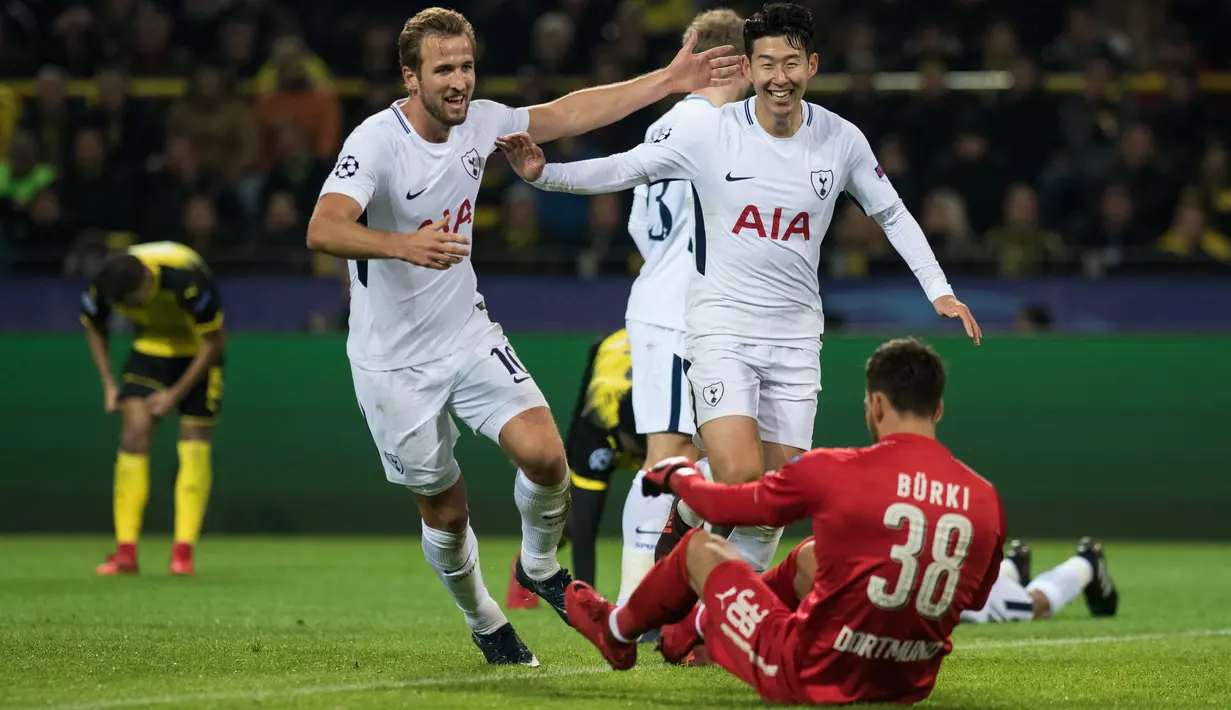 Pemain Tottenham Hotspur, Son Heung-Min dan Harry Kane berselebrasi setelah mencetak gol ke gawang Borussia Dortmund pada matchday kelima Liga champions Grup H di Stadion BVB, Selasa (21/11). Tottenham mencatatkan kemenangan 2-1. (Bernd Thissen/dpa /AFP)