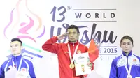 Atlet Wushu Indonesia, Yusuf Widiyanto (tengah) menerima medali emas pada Kejuaraan Dunia Wushu 2015 di Istora, Senayan, Jakarta, Selasa (17//11/2015). (Bola.com/Nicklas Hanoatubun)