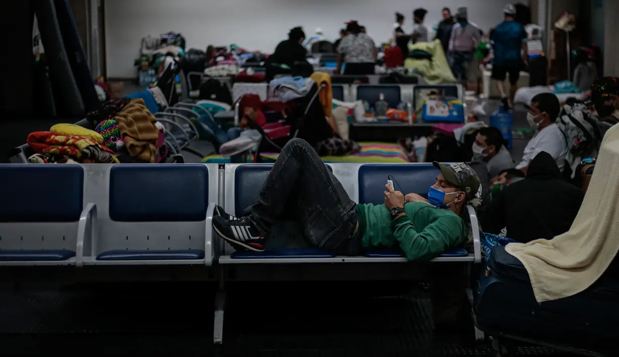 Imigran Kolombia yang terdampar tinggal di Bandara Internasional Guarulhos, di Guarulhos, dekat Sao Paulo, Selasa (26/5/2020). Lebih dari 200 warga Kolombia terlantar di bandara terbesar di Brasil ini menunggu "penerbangan kemanusiaan" dari pemerintah mereka. (Miguel SCHINCARIOL/AFP)