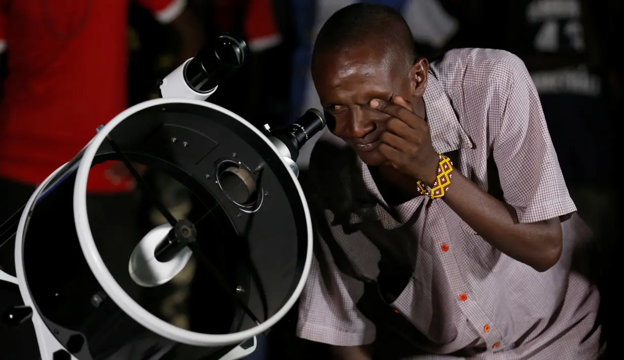 Seorang pria suku Maasai menggunakan teleskop melihat fenomena supermoon di desa Oloika, Shompole, perbatasan Kenya-Tanzanian border, (14/11). Fenomena ini merupakan bulan paling besar dan terang dalam kurun 70 tahun terakhir. (REUTERS/Thomas Mukoya)