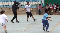 Bintang sepak bola David Beckham bermain sepak bola bersama anak-anak di kawasan pemukiman kumuh 1-11-14 di Buenos Aires, Senin (9/11/2015). Beckham berada Argentina untuk membuat film dokumenter tentang sepak bola. (AFP/FIXER-Argentina/Macarena GAGLIARD)