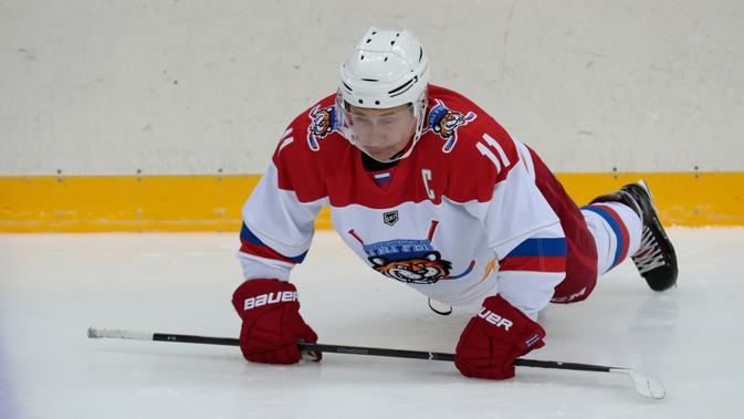 Presiden Rusia Vladimir Putin melakukan pemanasan sebelum bermain hoki es di Shayba Arena, Resor Laut Hitam Sochi, Rusia, (15/2). (Sergei Chirikov / Pool / AFP)