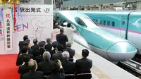 Warga saat menyambut dengan meriah kereta peluru Shinkansen tujuan Shin-hakodate-Hokuto di stasiun Tokyo, Sabtu (26/3). Dengan adanya jalur baru kereta supercepat ini perjalanan Tokyo-Hokkaido ditempuh hanya selama 4 jam 2 menit. (JIJI PRESS / AFP)