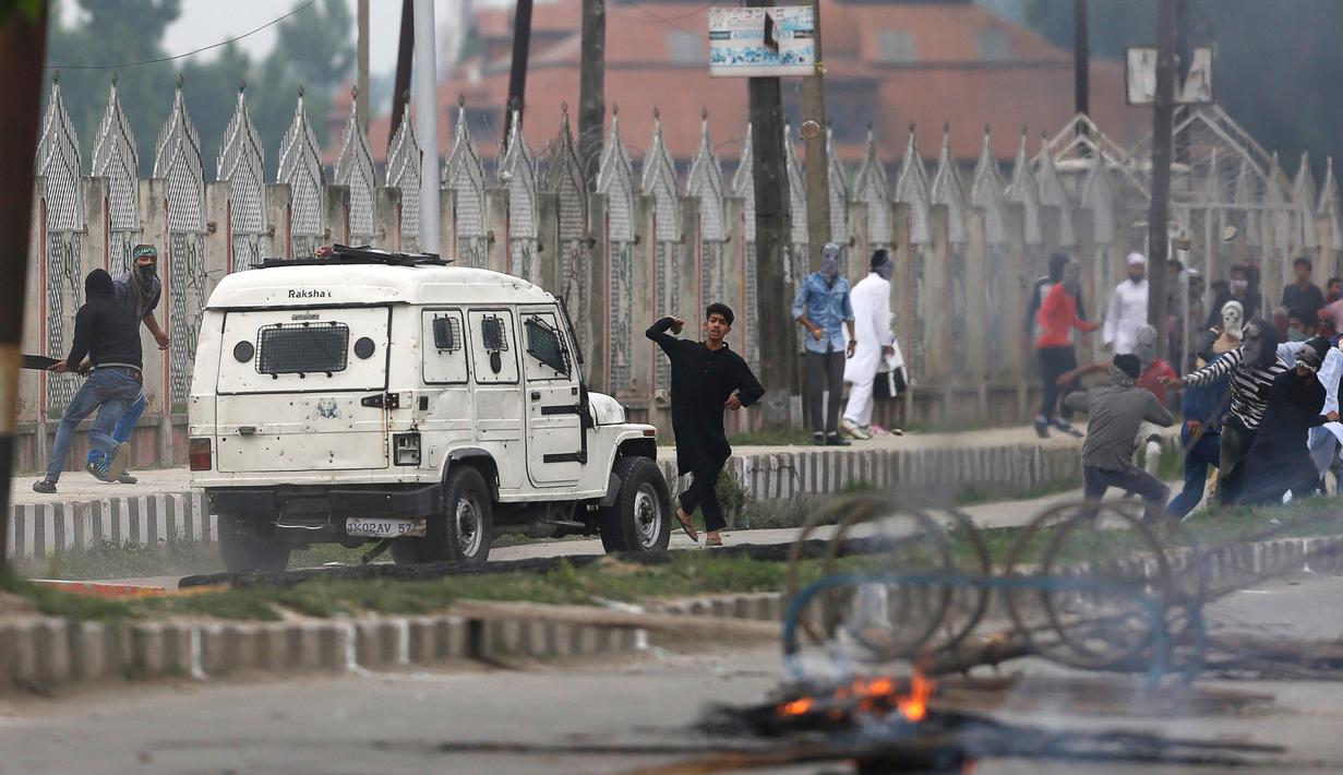 Seorang demonstran melempar batu kearah pasukan tentara saat menggelar aksi demo usai melakukan salat Idul Fitri di Srinagar, India (26/6). (AP Photo / Mukhtar Khan)
