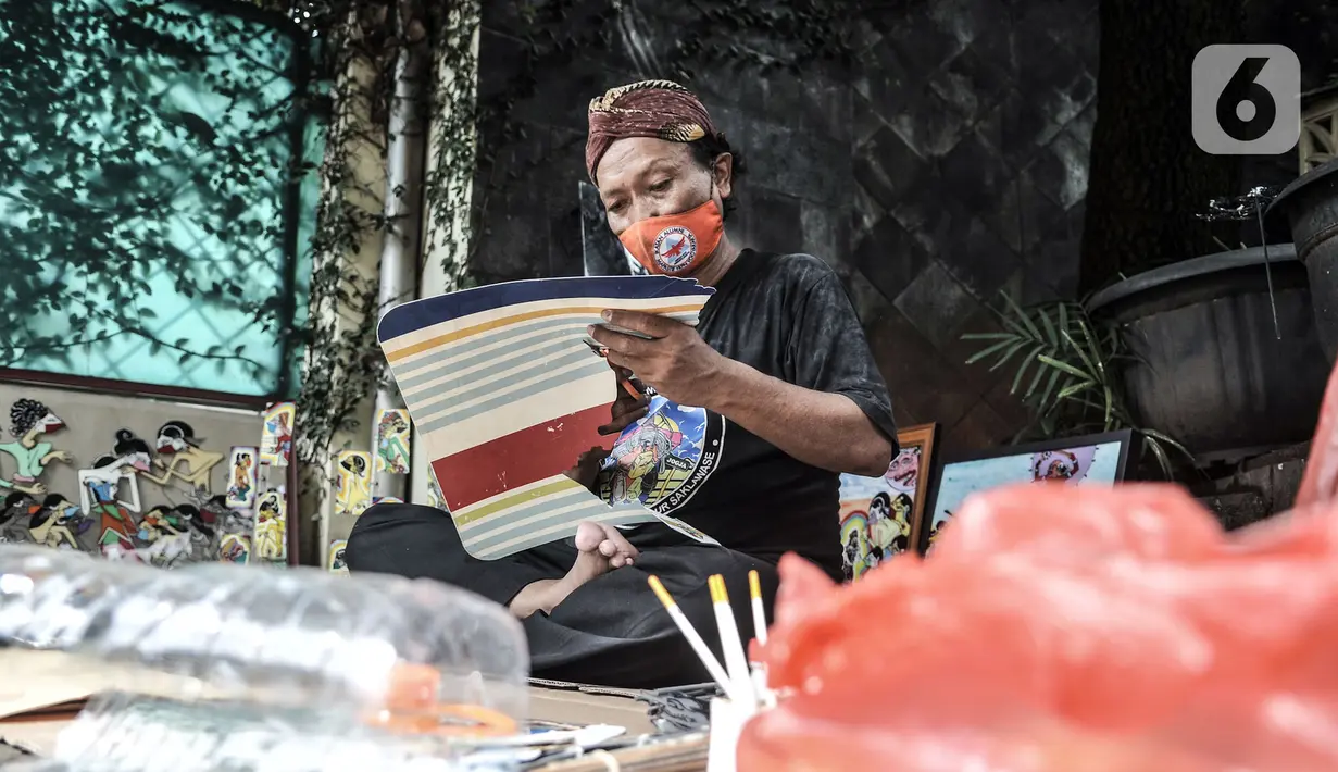 Seniman Iskandar Hardjodimuljo menyelesaikan pembuatan wayang uwuh di kawasan Cawang, Jakarta, Kamis (29/10/2020). Iskandar membuat wayang uwuh sebagai bentuk pelestarian budaya sekaligus mengajak masyarakat menjaga lingkungan dari sampah sehari-hari. (merdeka.com/Iqbal S. Nugroho)