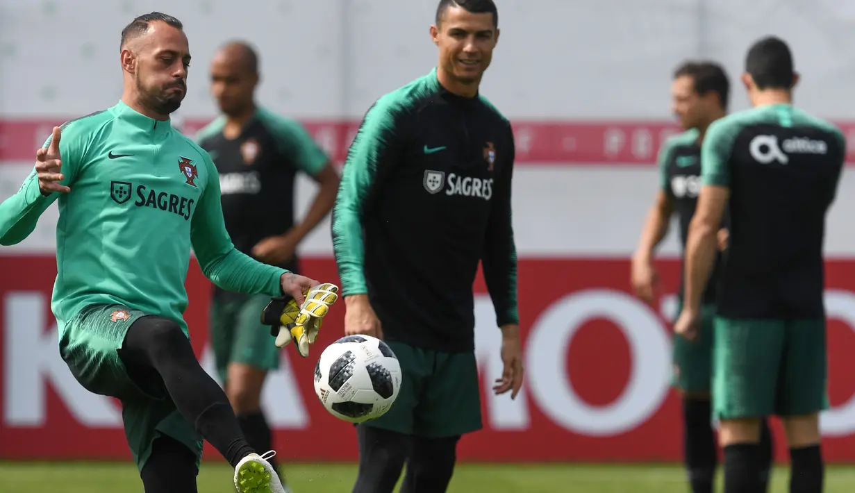 Kiper Portugal, Beto Pimparel menunjukan kebolehan saat ditonton Ronaldo pada sesi latihan di Kratovo, Moskow, (12/6/2018). Portugal akan mejalani laga perdana grup B melawan Spanyol. (AFP/Francisco Leong)