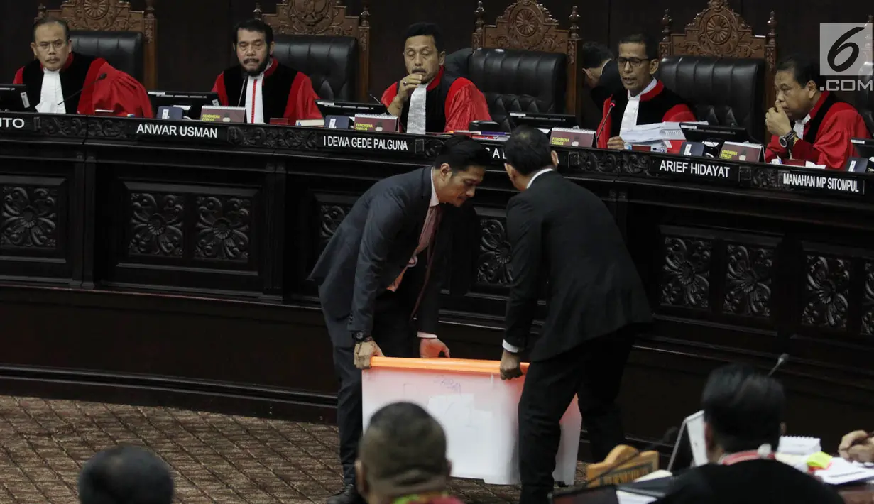 Petugas membawa kontainer berisi barang bukti milik BPN Prabowo-Sandiaga yang dihadirkan dalam sidang lanjutan sengketa Pilpres 2019 di MK, Jakarta, Rabu (19/6/2019). Sidang kali ini beragendakan mendengar keterangan saksi dan ahli terkait sengketa Pilpres 2019. (merdeka.com/Iqbal Nugroho)