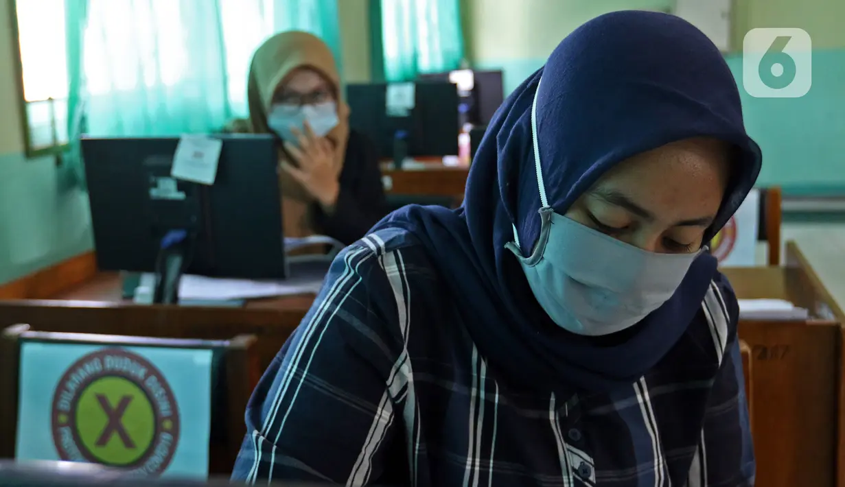 Siswi SMK PB Soedirman jurusan akuntansi melakukan persiapan Uji Sertifikasi Kompetensi (USK) bagi para siswa kelas XII di SMK PB Soedirman, Jakarta, Selasa (6/4/2021). USK dilakukan dengan tetap menerepakan protokol kesehatan. (Liputan6.com/Herman Zakharia)