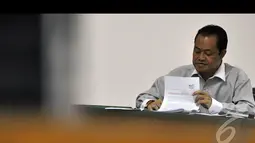 Muhtar Ependi melihat berkas saat menjalani sidang lanjutan di Pengadilan Tipikor, Jakarta, Kamis (15/1/2015). (Liputan6.com/Miftahul Hayat)