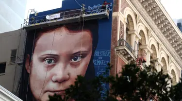 Pemandangan mural dengan gambar aktivis perubahan iklim Greta Thunberg asal Swedia di sebuah gedung di pusat Kota San Francisco, California, 11 November 2019. Mural setinggi 18 meter dan lebar 9 meter itu dibuat seniman jalanan asal Argentina, Andres Petreselli. (Justin Sullivan/Getty Images/AFP)