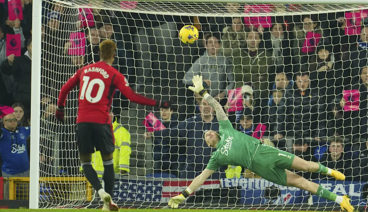 Kiper Everton, Jordan Pickford (kanan), tidak dapat menjangkau tendangan penalti pemain MU, Marcus Rashford, dalam pertandingan lanjutan Liga Inggris 2023/2024 melawan tuan rumah Everton yang berlangsung di Goodison Park Stadium, Liverpool, Senin (27/11/2023) dini hari WIB. (AP Photo/Jon Super)