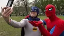 Dua pria bertopeng Spiderman dan Batman berfoto selfie saat memecahkan rekor dunia untuk karakter buku komik terbanyak dunia, Washington DC, (18/4/2014) (AFP Photo/Paul J. Ricards).