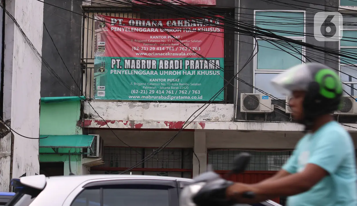Pengendara melintas di depan spanduk iklan agen perjalanan Umrah di Jakarta, Kamis (27/2/2020). Kementerian Haji dan Umrah Arab Saudi menangguhkan sementara pelayanan umrah bagi warga dari luar kerajaan sebagai upaya mencegah penyebaran virus corona atau Covid-19. (Liputan6.com/Angga Yuniar)