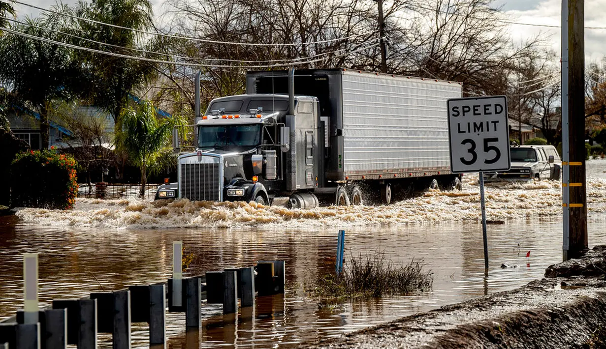 Sebuah truk melewati banjir usai badai di Merced, California, Amerika Serikat, 10 Januari 2023. Serangkaian badai yang menghantam California telah menyebabkan jalanan terendam banjir, gelombang tinggi air laut, sungai meluap, dan memaksa ribuan orang untuk mengungsi. (AP Photo/Noah Berger)