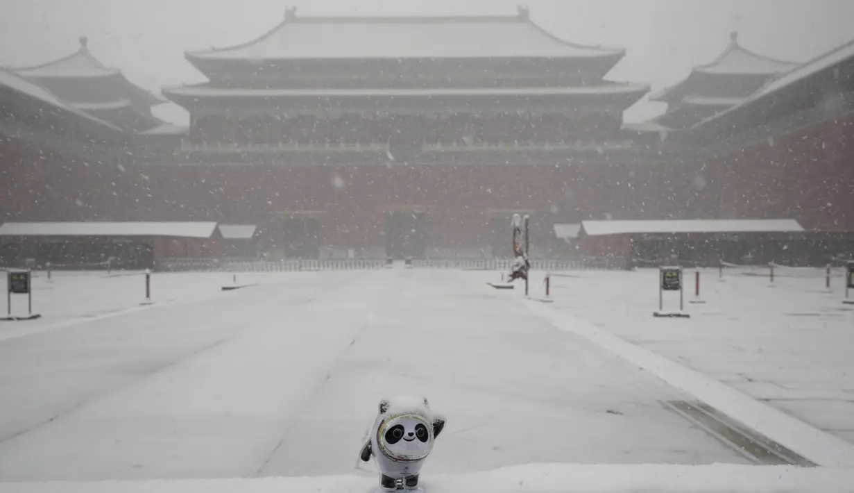 Patung Bing Dwen Dwen, maskot Olimpiade Musim Dingin 2022 terlihat di gerbang Kota Terlarang saat salju turun di Beijing, China (18/3/2022). Gelombang dingin melanda banyak bagian China, menyebabkan suhu turun dan mengganggu lalu lintas di daerah yang terkena dampak. (AP Photo/Ng Han Guan)