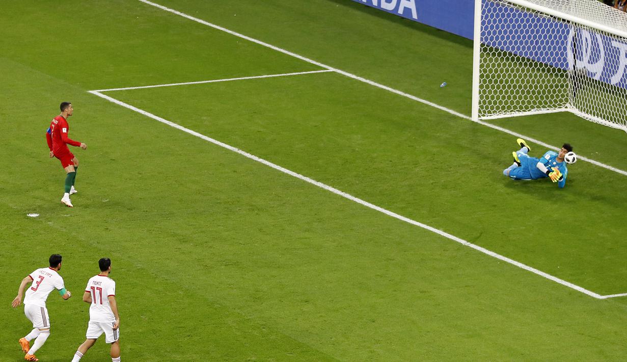 Kiper Iran, Ali Beiranvand (kanan) berhasil mengamankan bola sepakan penalti Cristiano Ronaldo pada laga grup B Piala Dunia 2018 di Mordovia Arena, Saransk, Rusia, (25/6/2018). Portugal dan Iran bermain imbang 1-1. (AP/Darko Bandic)