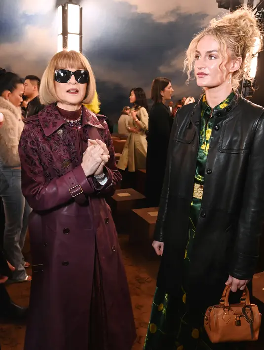 Anna Wintour tampil dengan serba deep burgundy yang padukan dress berkerah mandarin dan long coat. Long coat kulit dengan embroidery velvet yang menawan [Burberry]