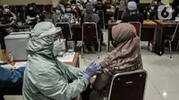 Tenaga pendidik saat menerima vaksinasi Covid-19 di GOR Tanjung Priok, Jakarta Utara, Selasa (6/4/2021). Vaksinasi Covid-19 dilakukan sebagai upaya meningkatkan kekebalan kepada para pengajar jelang uji coba sekolah tatap muka. (merdeka.com/Iqbal S. Nugroho)