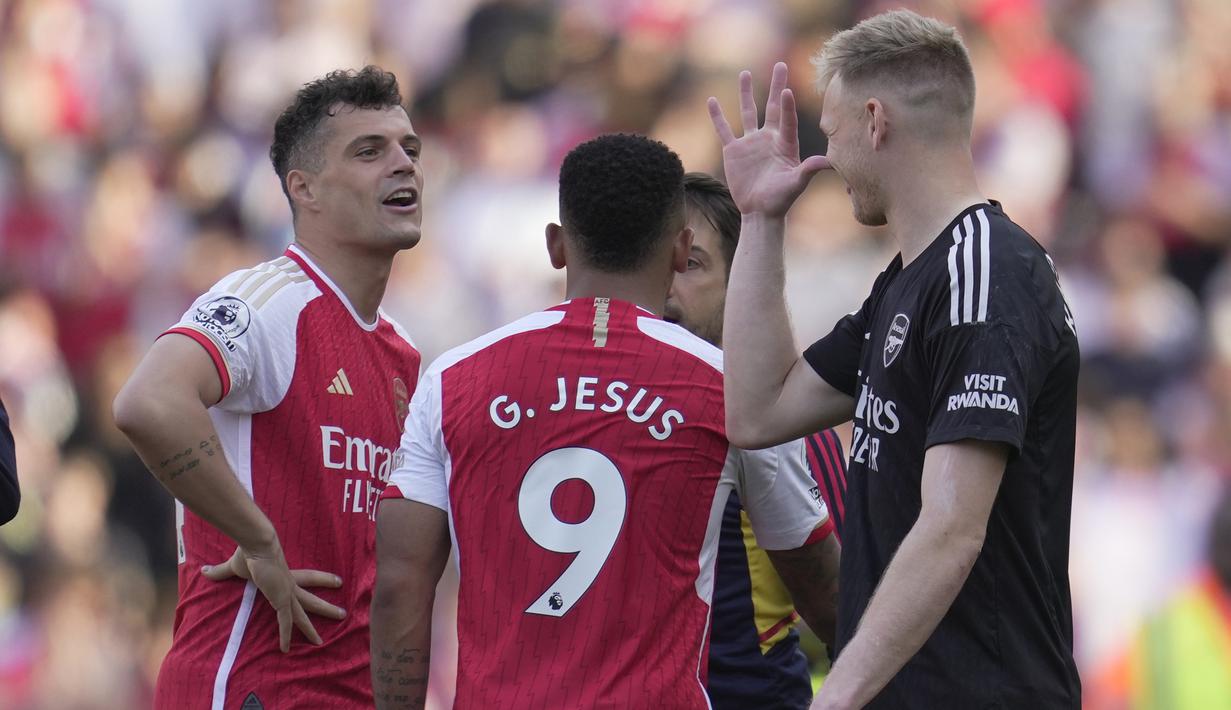 Penjaga gawang Arsenal, Aaron Ramsdale (kanan) mengejek dengan cara menirukan gaya selebrasi yang sering dilakukan rekan satu timnya yaitu, Garnit Xhaka (kiri) setelah laga pamungkas English Premier league 2022/2023 melawan Wolverhampton Wanderers yang berlangsung di Emirates Stadium, Minggu (28/5/2023). (AP Photo/Kin Cheung)