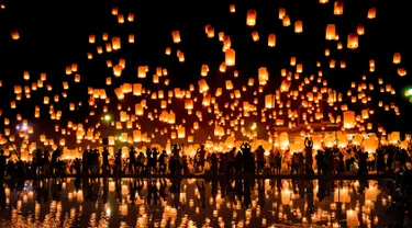 Sejumlah orang melepaskan lampion ke udara saat mereka merayakan festival Yee Peng di Chiang Mai (3/11). Dalam festival ini, ratusan bahkan ribuan orang beramai-ramai menerbangkan lampion ke udara. (AFP Photo/Roberto Schmidt)