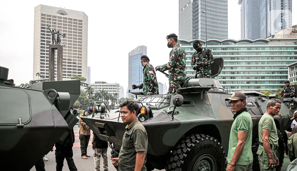 Tentara berdiri di atas alat utama sistem senjata (alutsista) milik TNI saat perayaan HUT ke-77 TNI di Bundaran HI, Jakarta, Rabu (5/10/2022). Kegiatan yang diikuti oleh seluruh kesatuan jajaran TNI ini dalam rangka menyambut HUT ke-77 TNI. (Liputan6.com/Faizal Fanani)