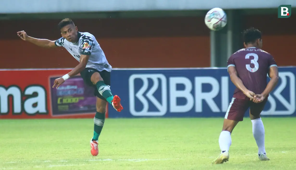 Pemain Persikabo 1973, Ahmad Nufiandani (kiri) melepaskan tendangan di depan pemain PSM Makassar, Zulkifli Syukur dalam laga pekan ke-9 BRI Liga 1 2021/2022 di Stadion Maguwoharjo, Sleman, Selasa (26/10/2021). (Bola.com/Nandang Permana)