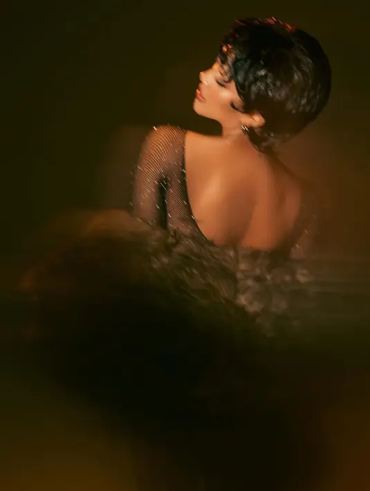 Jumpsuit backless tersebut dipadukan syal berbulu motif leopard kecoklatan. Ia pun mengenakan anting-anting silver.  [@riomotret]