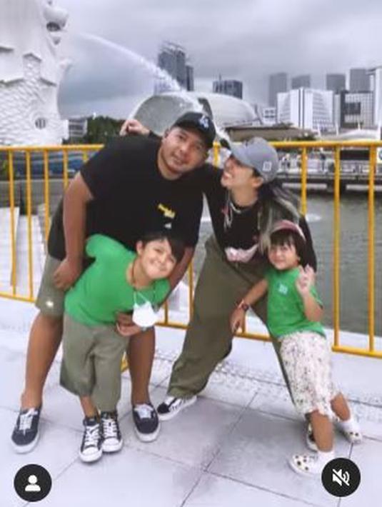 Di Singapura, rasanya tak afdol bila tak berpose di Taman Merlion. Hal itu juga dilakukan keluarga Chua Kotak, yang memperlihatkan Singa memancurkan air dari mulutnya. (Foto: Instagram/@chuakotak)