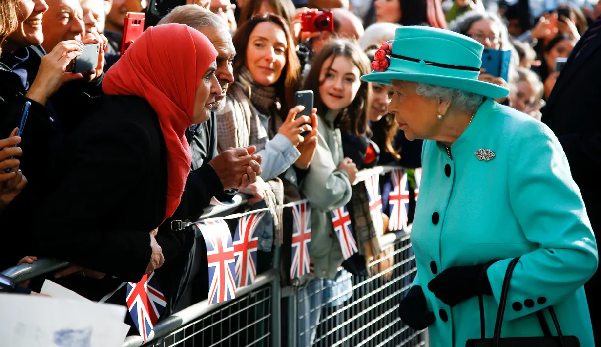Ratu Elizabeth II menyapa warga saat tiba di pusat perbelanjaan Lexicon saat berkunjung ke Bracknell, London, Jumat (19/10). Ratu Elizabeth menghabiskan sebagian waktu siangnya untuk mengunjungi department store. (HENRY NICHOLLS/ POOL/AFP)