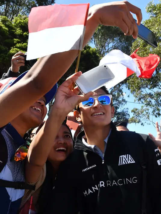 Penggemar mengajak pembalap Indonesia Rio Haryanto berselfie jelang debut pada ajang Formula 1 di GP Australia, Melbourne, Minggu (20/3). Rio akan membuat sejarah sebagai pembalap Indonesia pertama yang turun di ajang balap jet darat ini. (Paul Crock/AFP)