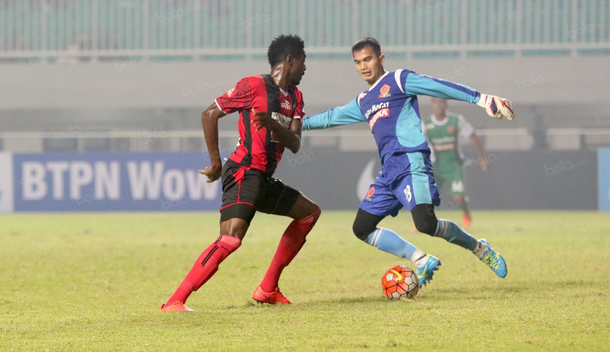 Kiper PS TNI, Dika Bhayangkara dihadang pemain Persipura Jayapura Foday Eddy Boakay  pada laga Torabika SC 2016 di Stadion Pakansari, Bogor, Minggu (19/6/2016). (Bola.com/Nicklas Hanoatubun)
