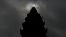 Gerhana matahari parsial terlihat di dekat Monumen Kemerdekaan di Phnom Penh, Kamboja, (9/3/2016). Gerhana matahari total terjadi di sejumlah daerah di Indonesia. (Reuters/ Samrang Pring)