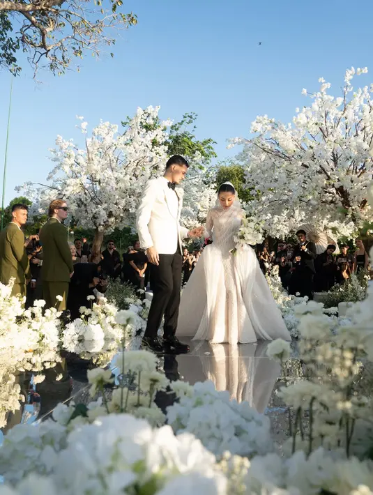 Detail yang paling mencuri perhatian hadir pada bagian bodice. Christie Basil menghadirkan teknik draping artistik yang membentuk garis-garis lembut mengikuti lekuk tubuh Jennifer. Siluet ini memberikan kesan ramping sekaligus anggun, tanpa menghilangkan nuansa romantis yang menjadi identitas gaun tersebut. [@jennifercoppenreal20].