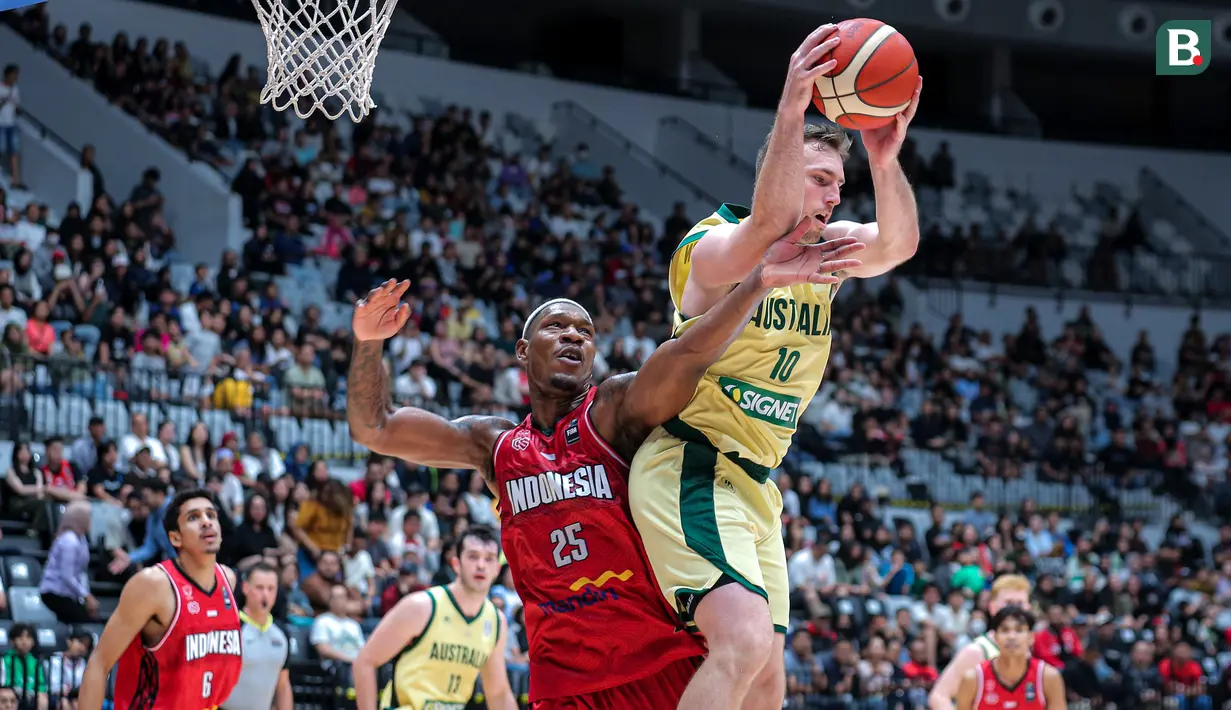 Pemain Timnas Basket Indonesia, Lester Prosper (tengah kiri) berusaha merebut bola dari pemain Timnas Basket Australia, Mitchell Mccarron saat laga Kualifiasi Piala Asia 2025 di Indonesia Arena, Senayan, Jakarta, Minggu (25/02/2024). (Bola.com/Bagaskara Lazuardi)