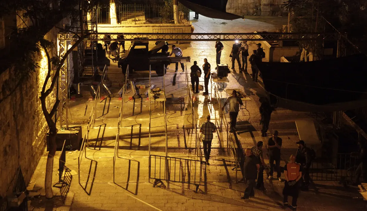 Aparat keamanan Israel membongkar detektor logam di depan pintu masuk kompleks Masjid Al Aqsa di Kota Tua Yerusalem, Selasa (25/7) dini hari. Hal itu dilakukan, setelah PM Israel Benyamin Netanyahu mengambil voting kabinet. (AP Photo/Mahmoud Illean)