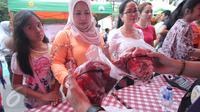 Warga tengah membeli daging murah di Jakarta, Minggu (21/2). Kementerian Pertanian (Kementan) bersama PT Berdikari (Persero) menggelar operasi pasar dengan penjualan paket daging sapi lokal terjangkau. (Liputan6.com/Angga Yuniar)