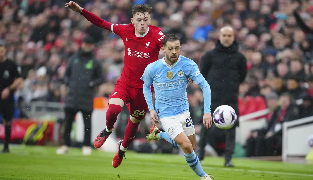 Gelandang Manchester City, Bernardo Silva (kanan) berusaha melewati bek Liverpool, Conor Bradley pada laga pekan ke-28 Premier League 2023/2024 di Anfield Stadium, Liverpool, Minggu (10/3/2024). (AP Photo/Jon Super)