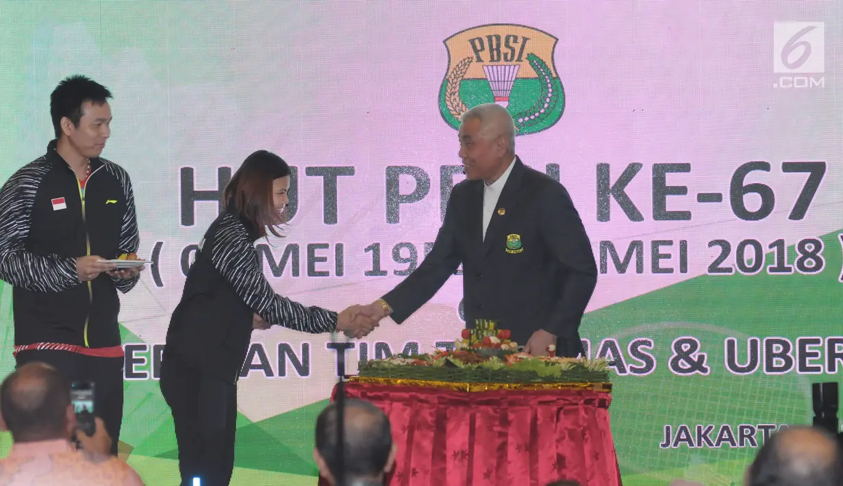 Ketua Harian PBSI, Alex Tirta (kanan) menyerahkan potongan tumpeng kepada Kapten tim bulutangkis puteri Indonesia untuk Uber Cup 2018, Greysia Polii saat upacara pelepasan di Jakarta, Selasa (8/5). (Liputan6.com/Helmi Fithriansyah)